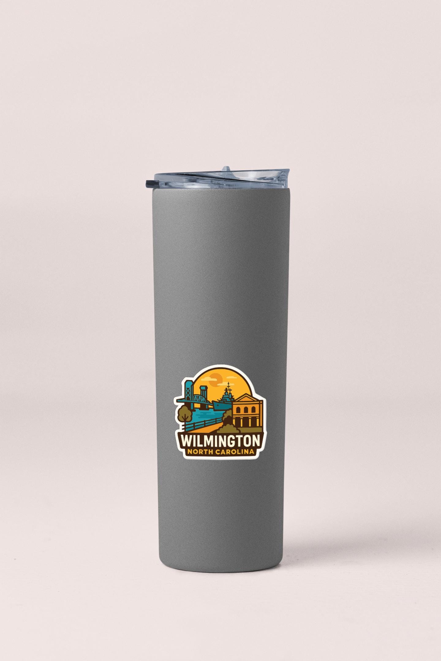 A gray insulated tumbler with a sticker depicting a cityscape and the text "WILMINGTON NORTH CAROLINA".