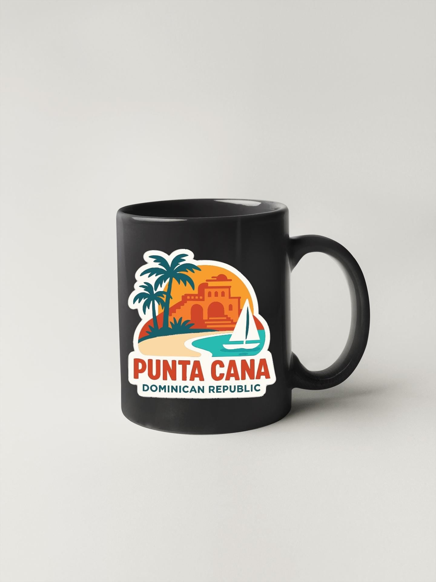 A black coffee mug with a colorful graphic depicting a tropical island scene, including palm trees, a building, and a sailboat.
