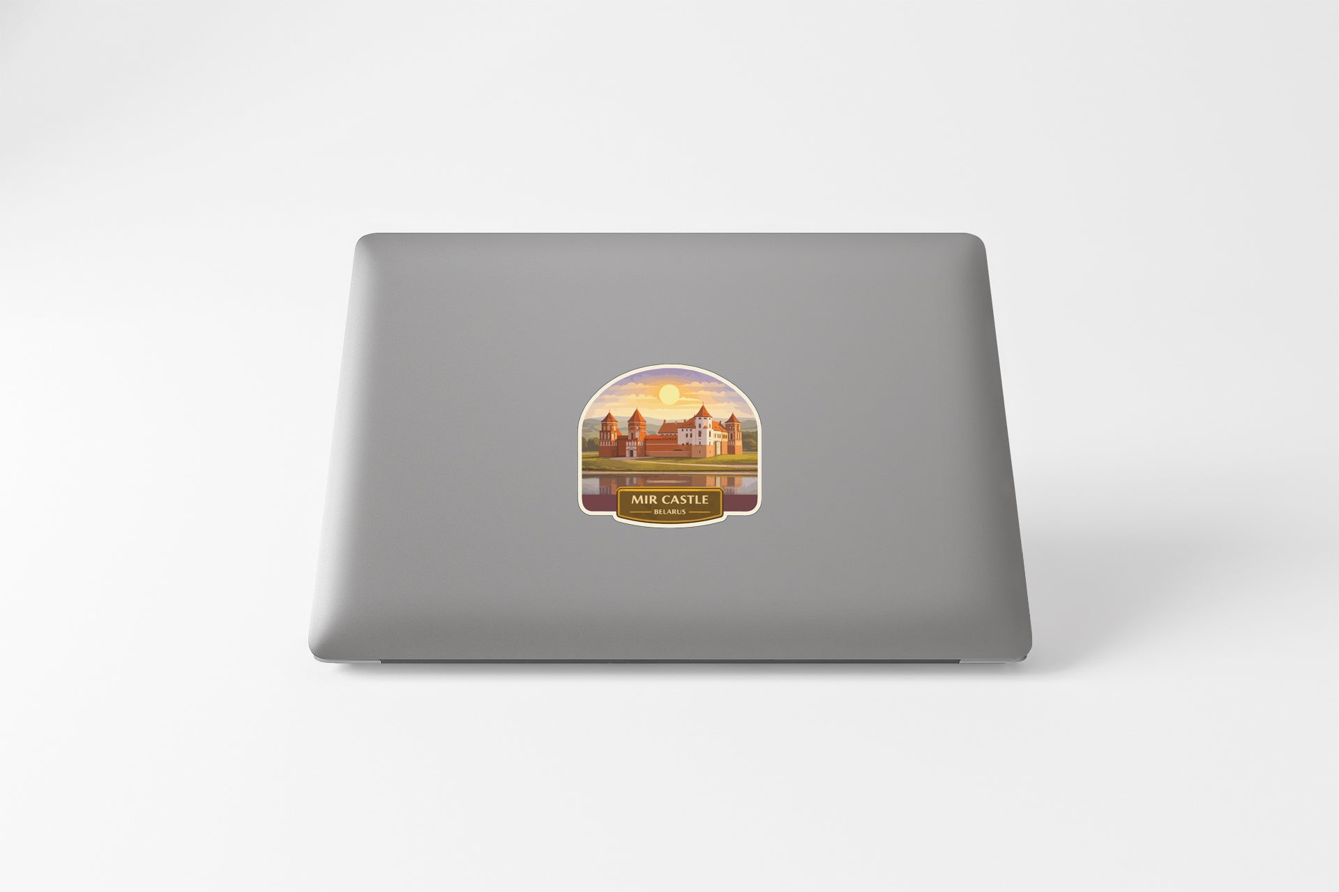 a sticker with a scenic illustration of a castle on a laptop.