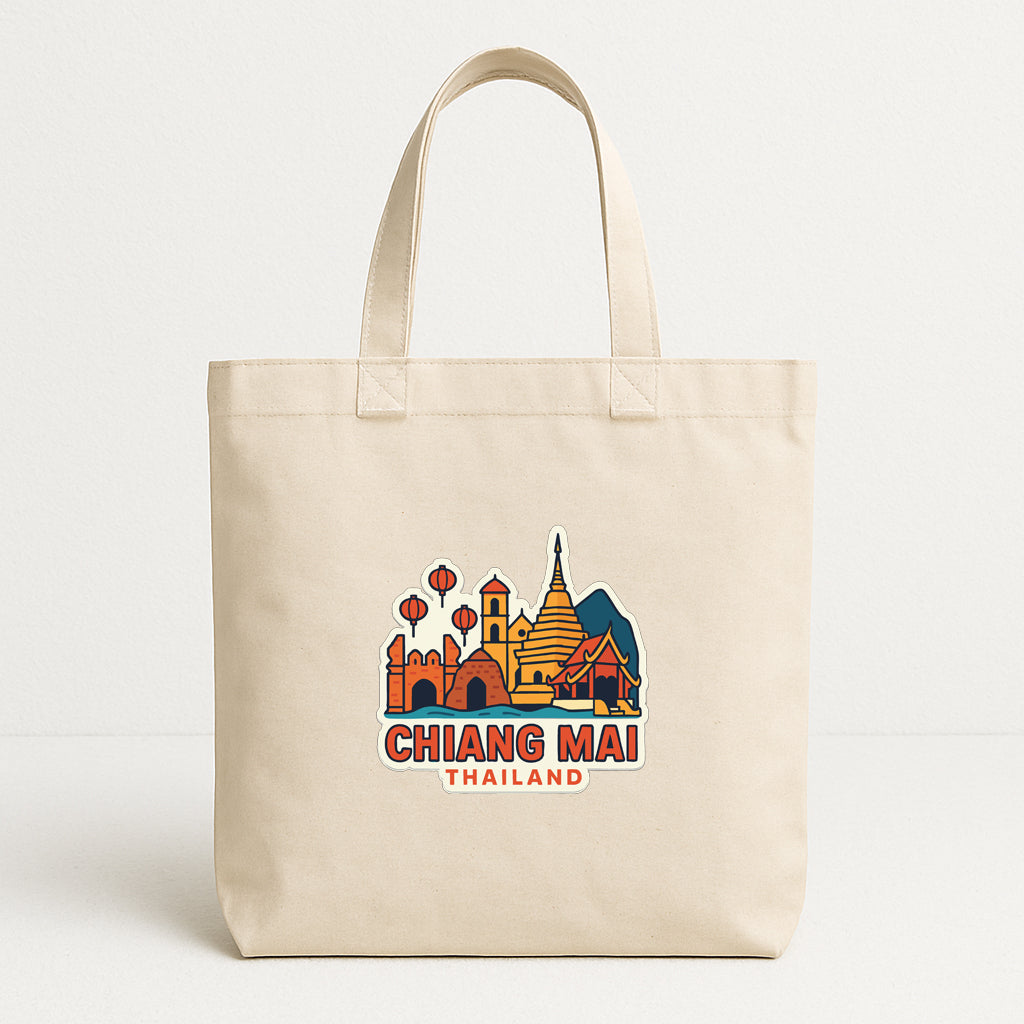 A beige tote bag with a printed design of a city skyline and text that says "CHIANG MAI THAILAND".