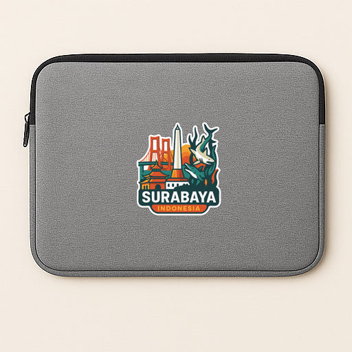 a gray laptop sleeve with a sticker of Surabaya, Indonesia, on it.