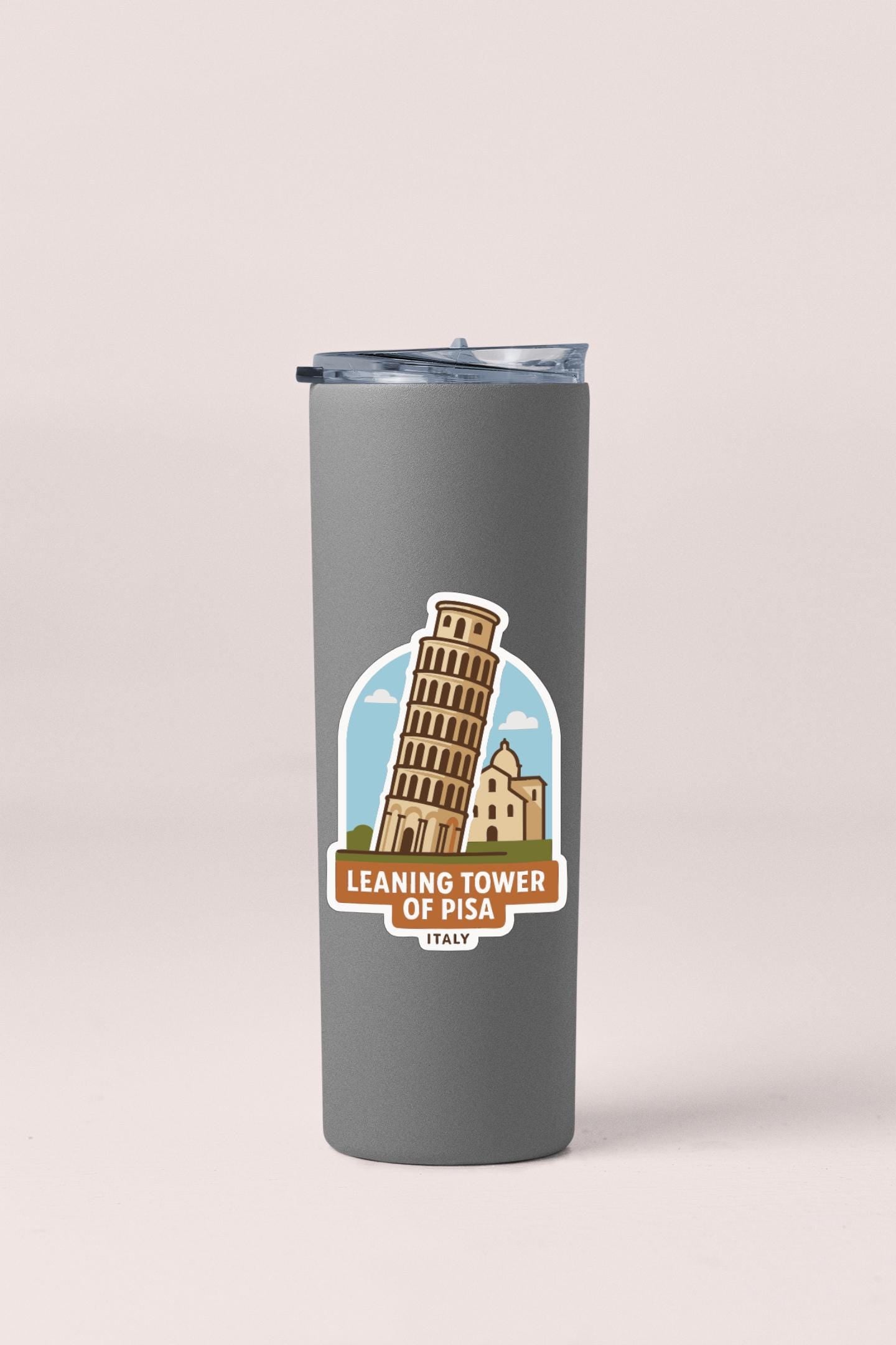 A gray insulated tumbler with a sticker depicting the Leaning Tower of Pisa, a famous landmark in Italy.