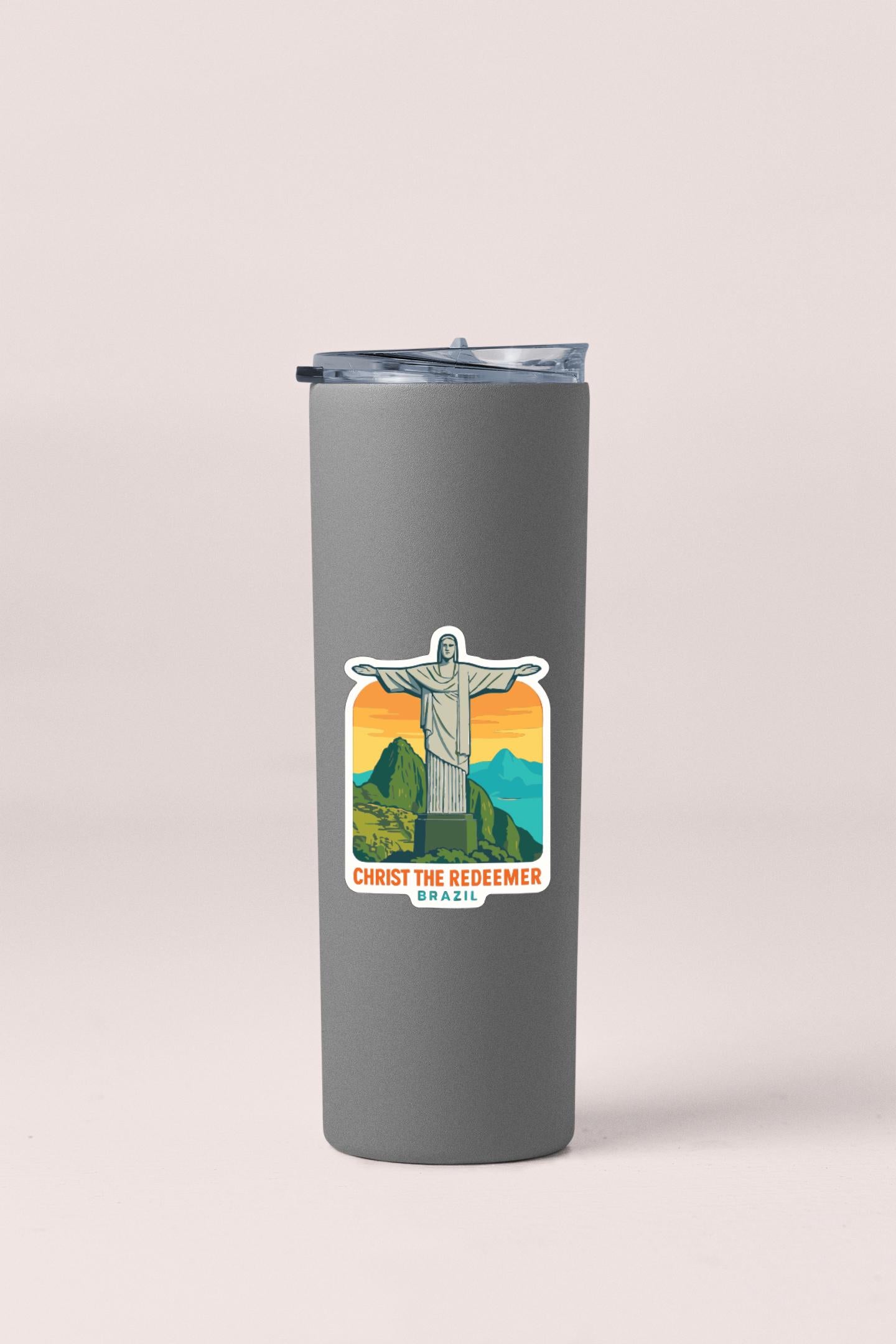 A gray tumbler with a sticker depicting the Christ the Redeemer statue in Brazil.