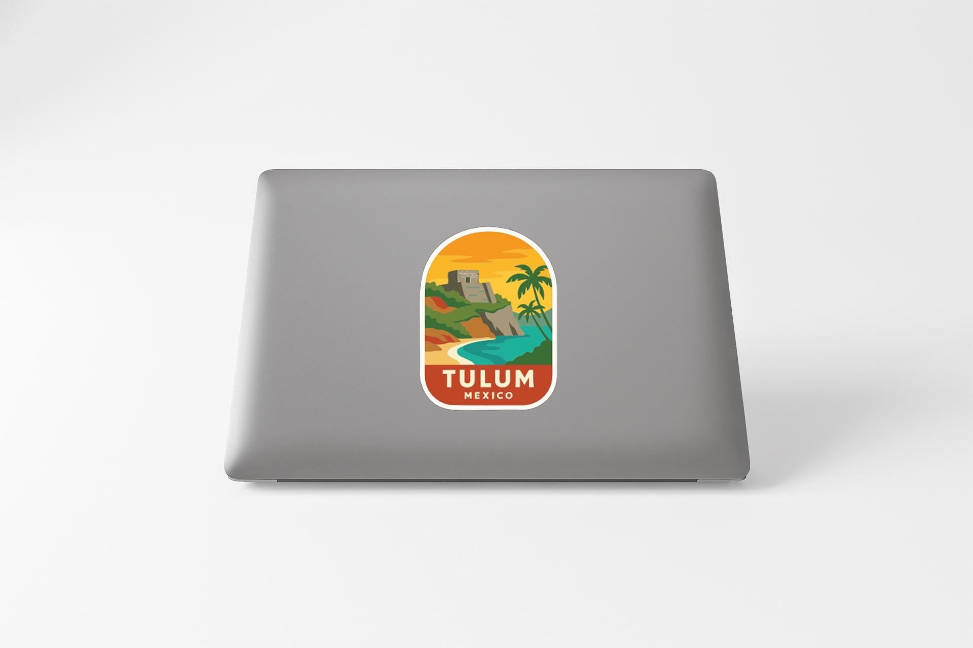 A sticker depicting a tropical landscape with a castle, palm trees, and a body of water, representing the city of Tulum, Mexico.