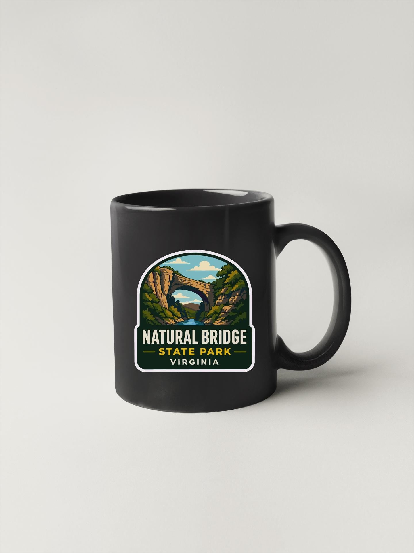 A black coffee mug with a sticker depicting the Natural Bridge in Virginia.