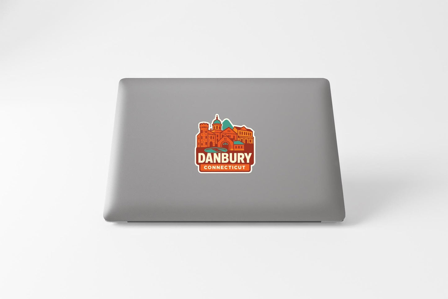 a sticker with an illustration of a cityscape on the back of a laptop.