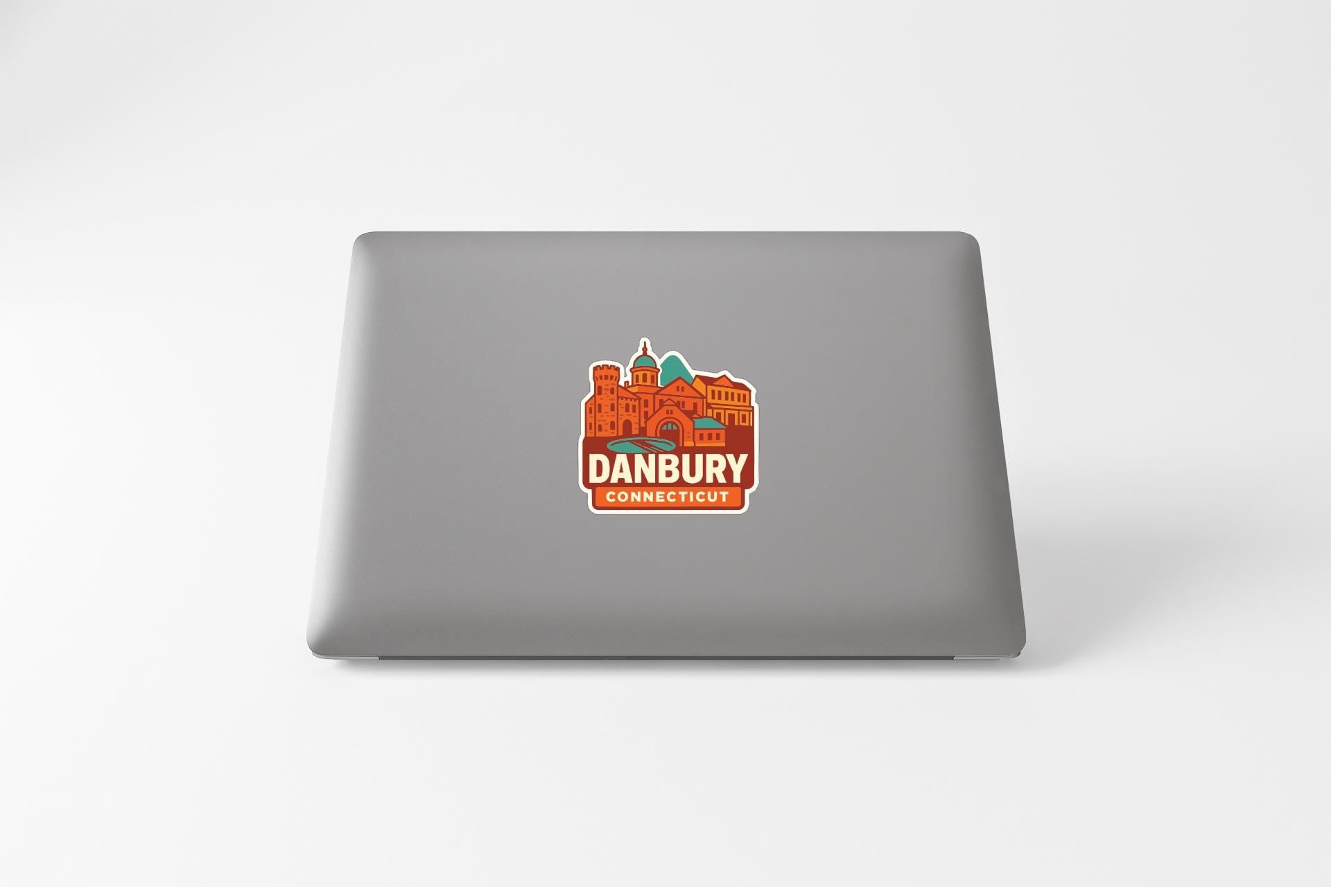 a sticker with an illustration of a cityscape on the back of a laptop.