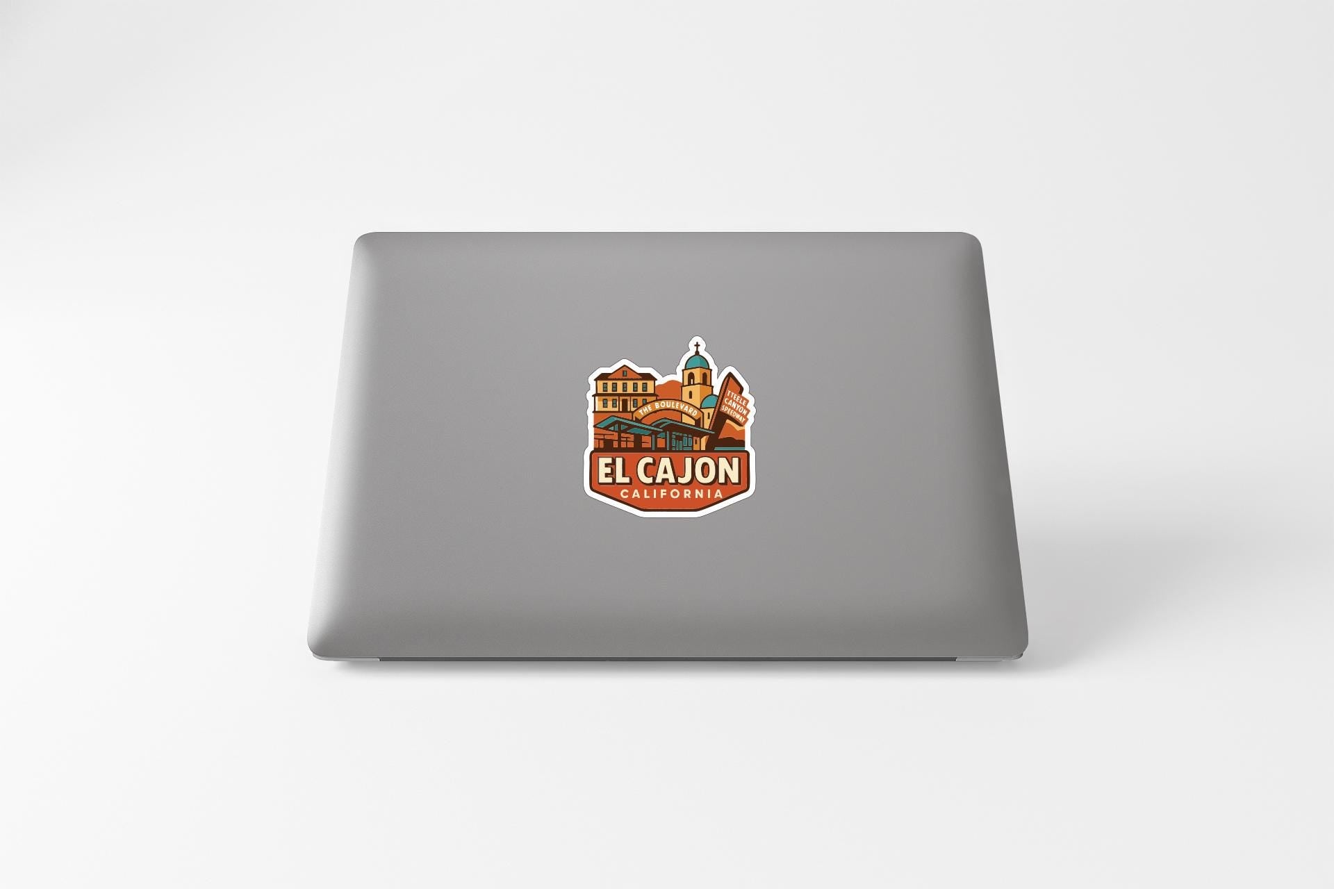 a sticker with a graphic of a building and the text "EL CAJON, CALIFORNIA" on a laptop.