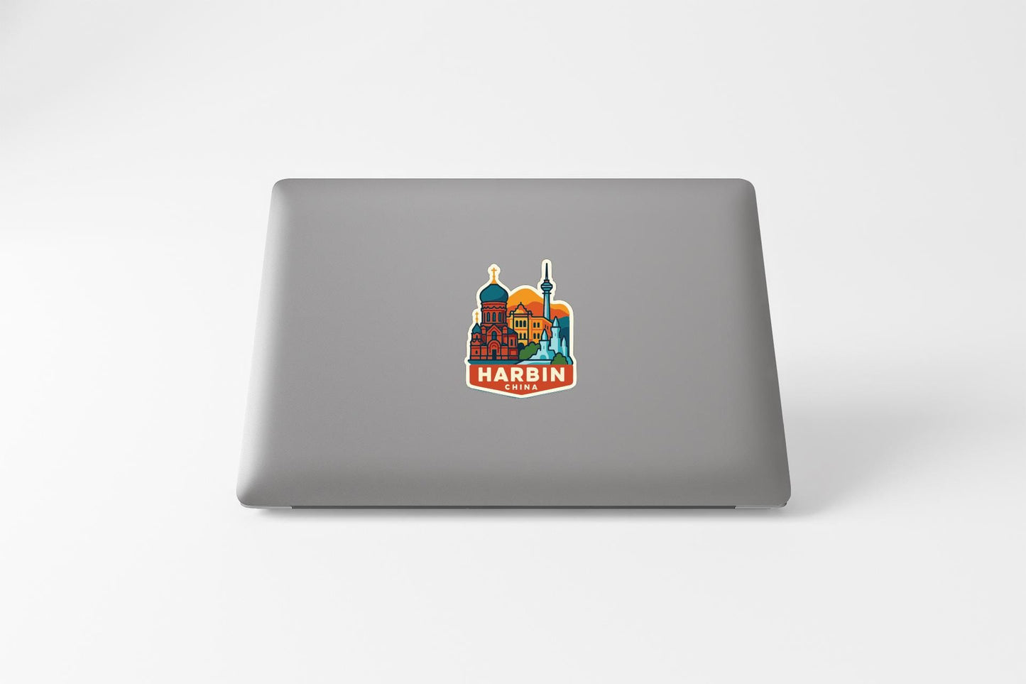 a sticker with a colorful illustration of a city skyline on the back of a laptop.