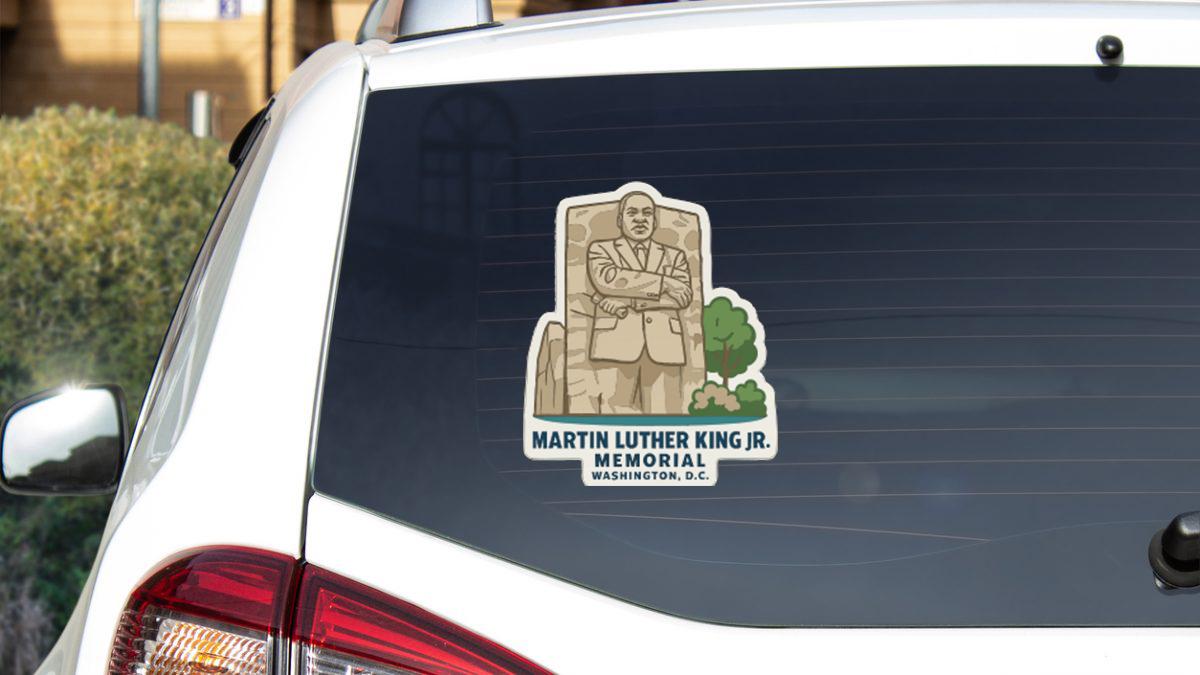 A sticker on the rear window of a car featuring a portrait of Martin Luther King Jr.