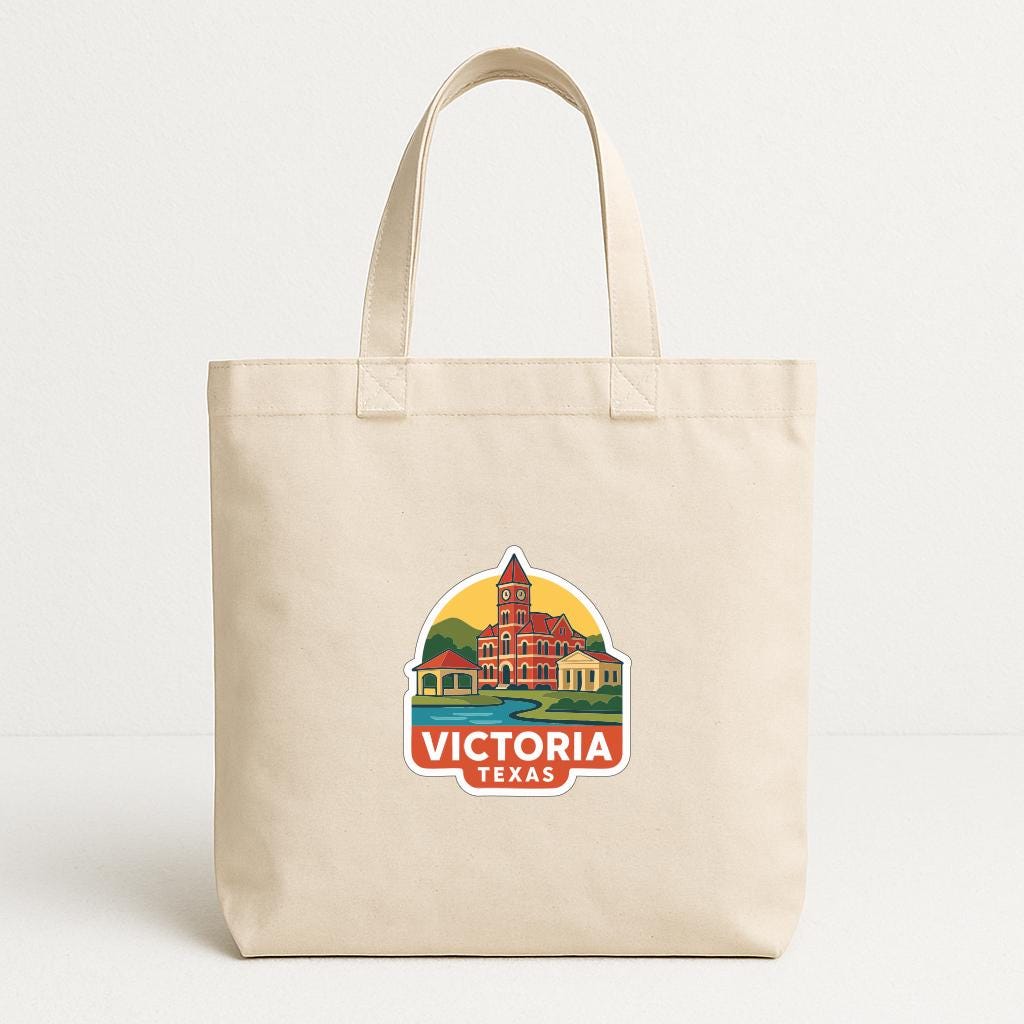 A beige tote bag with a printed image of a building and the text "VICTORIA TEXAS" on it.