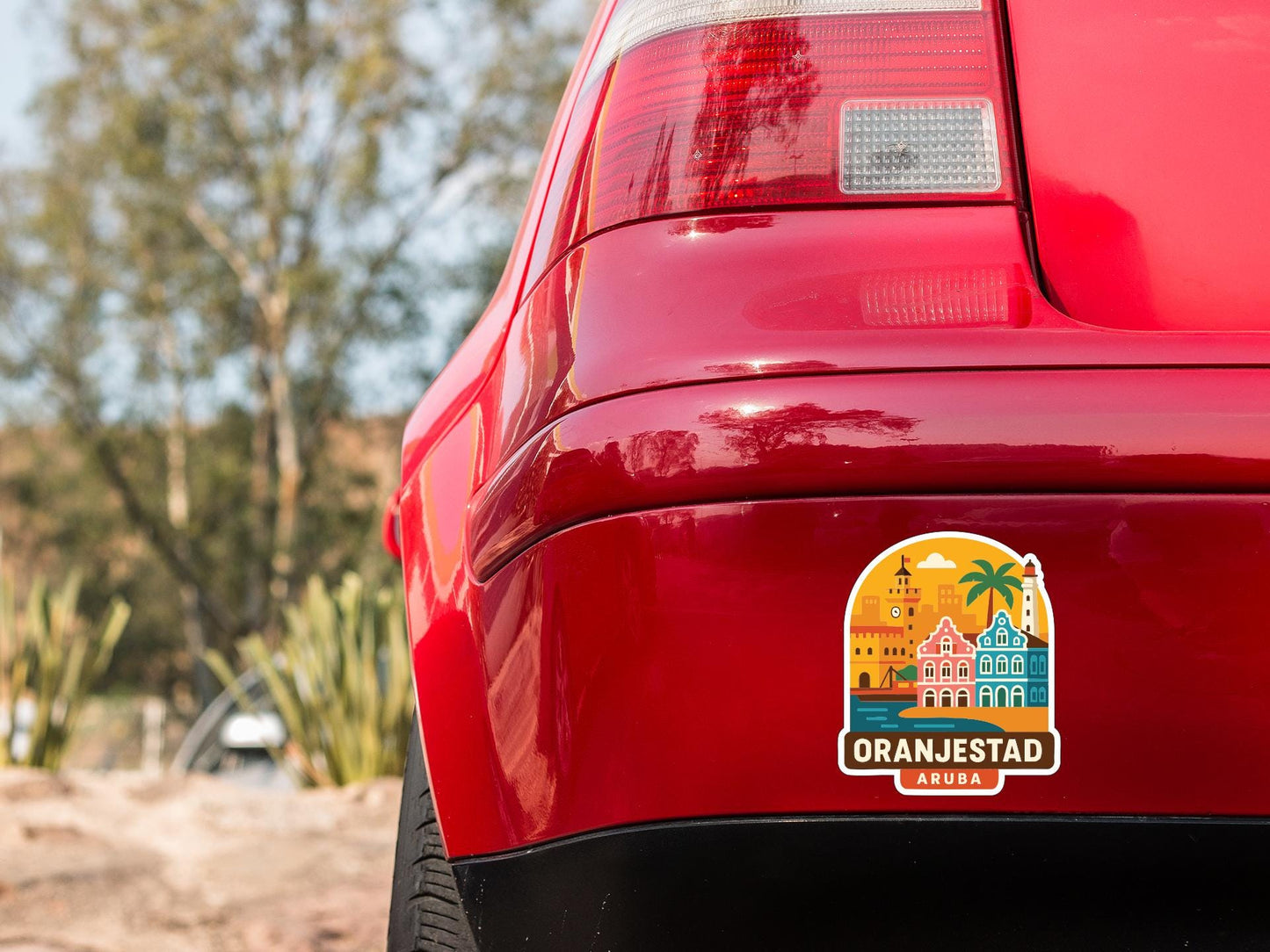 the rear end of a red car with a sticker on the trunk that says "Oranjestad, Auroba".