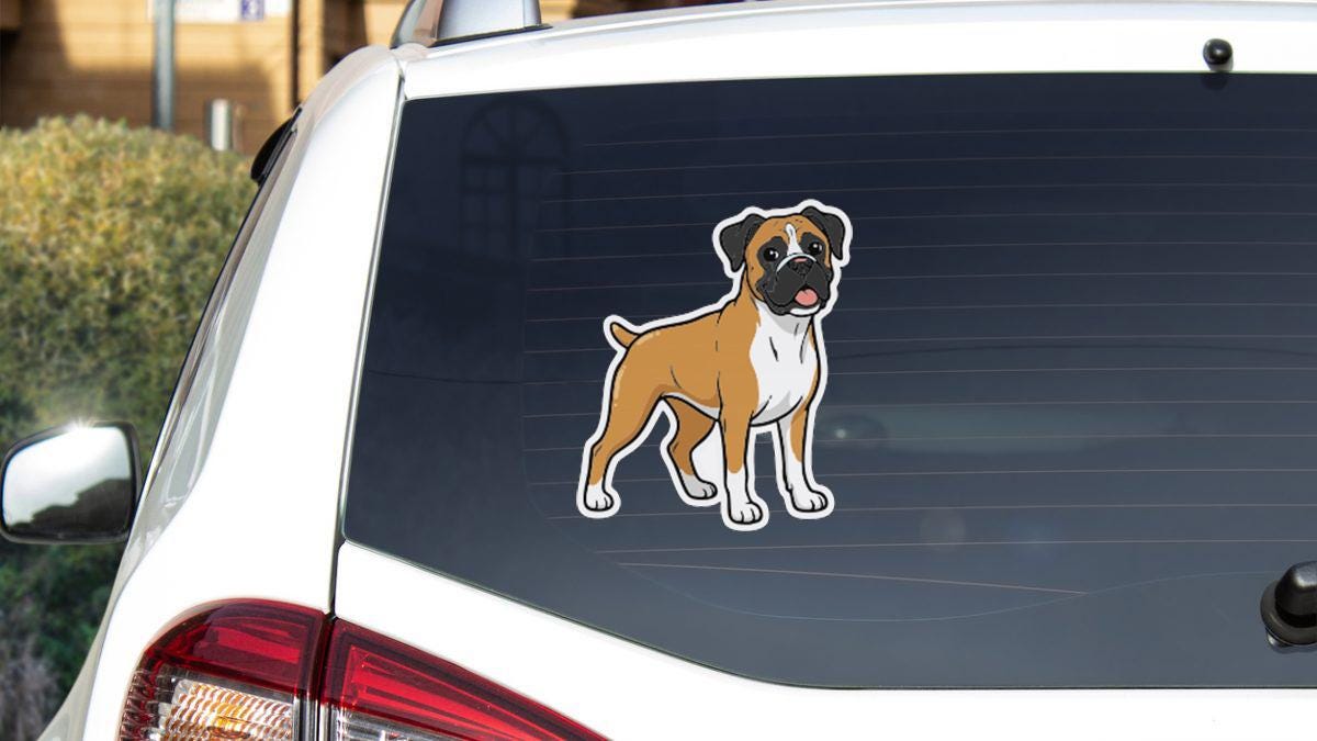 a sticker of a dog on the rear window of a car.