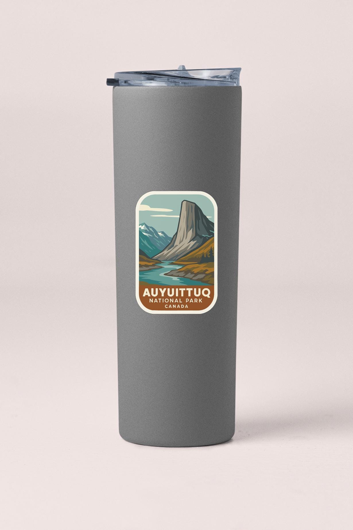 A gray tumbler with a label that says "AUYUITTUO NATIONAL PARK CANADA" on it.