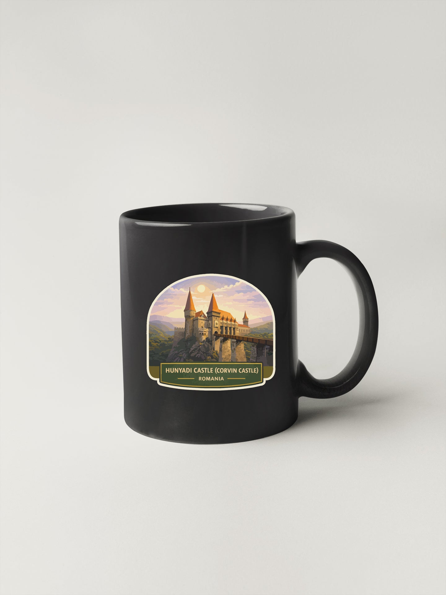 A black coffee mug with a printed image of the Hunniedi Castle in Romania.