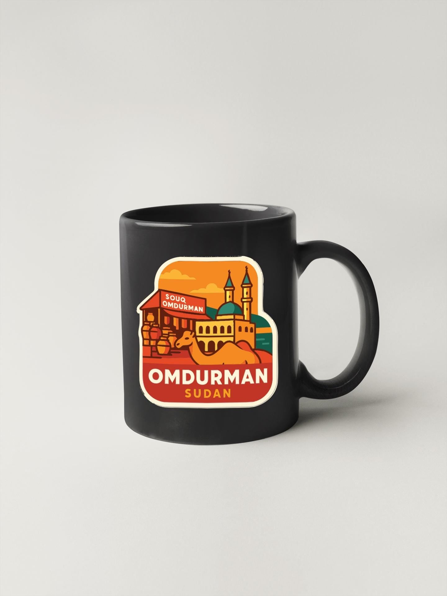A black coffee mug with a colorful illustration of a cityscape and the text "OMDURMAN SUDAN" printed on it.
