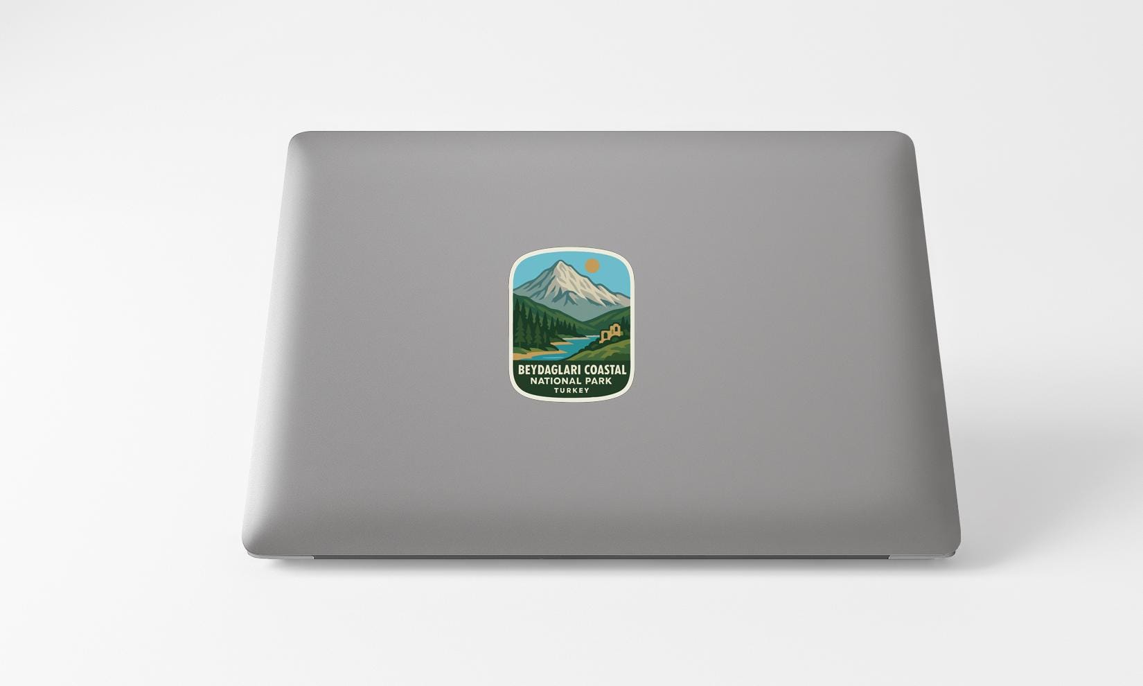 A sticker with a mountain landscape and text on a laptop.