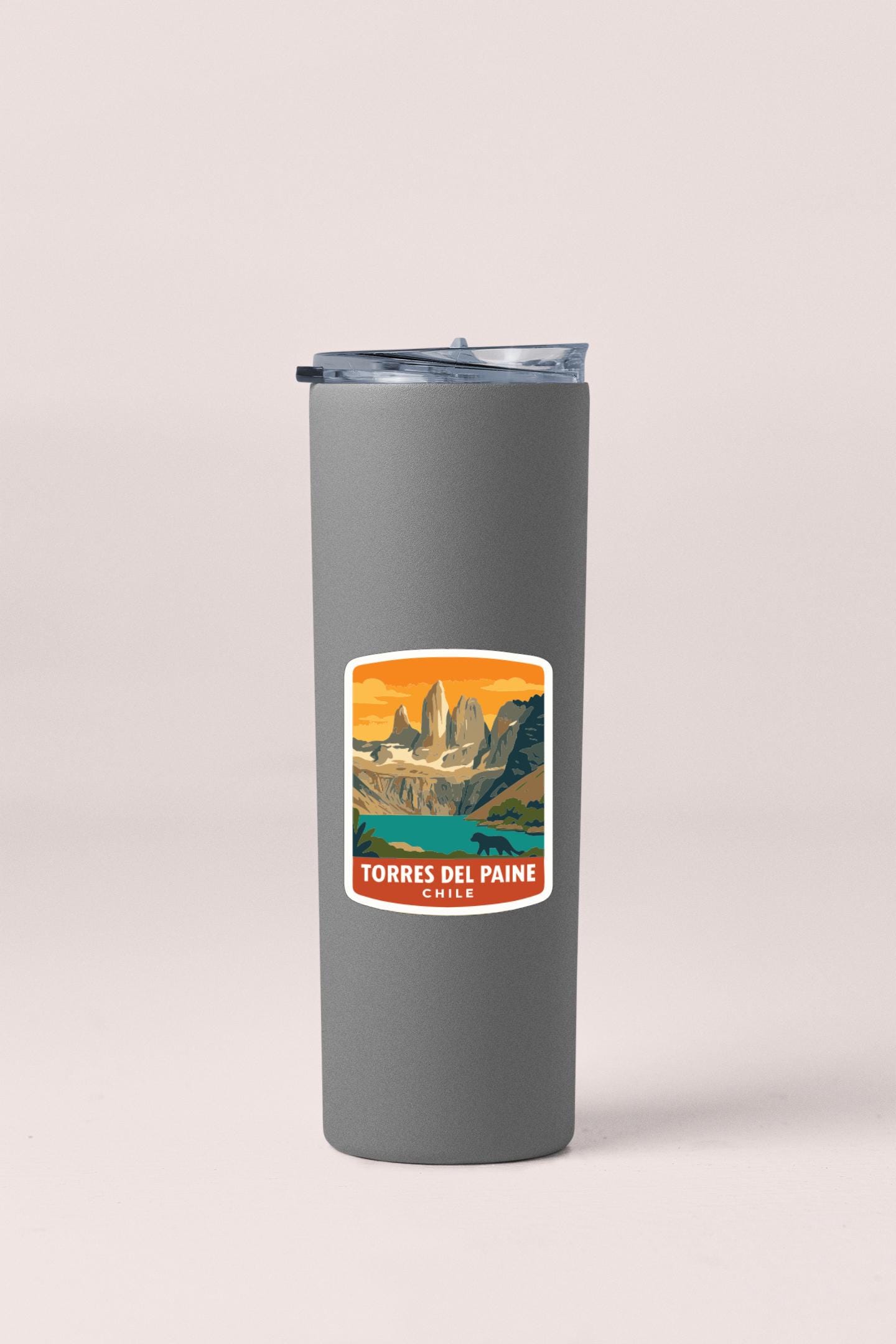 A gray insulated tumbler with a label that features an illustration of a mountain range and the text "TORRES DEL PAINE CHILE".