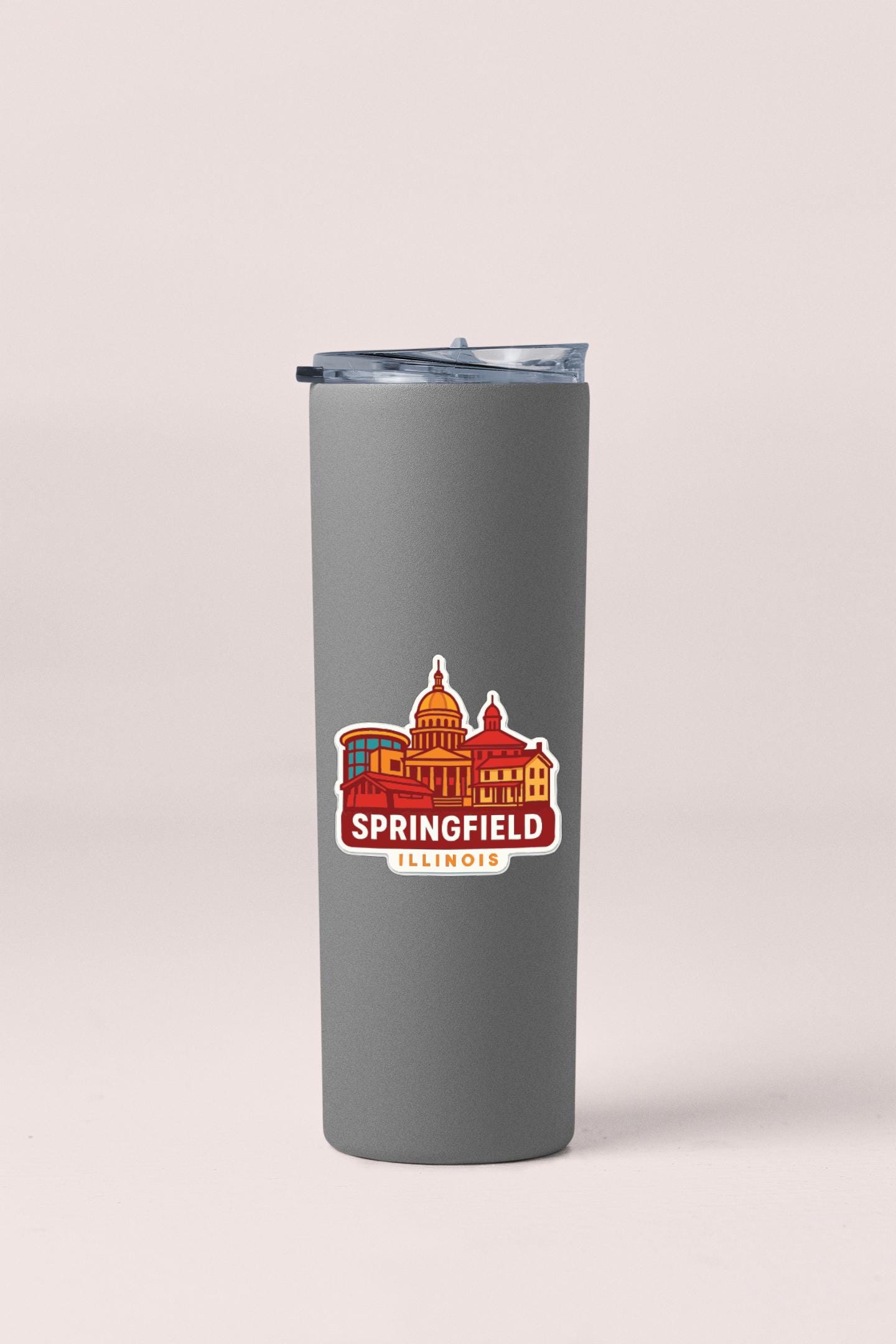 A gray insulated tumbler with a sticker depicting the city of Springfield, Illinois.