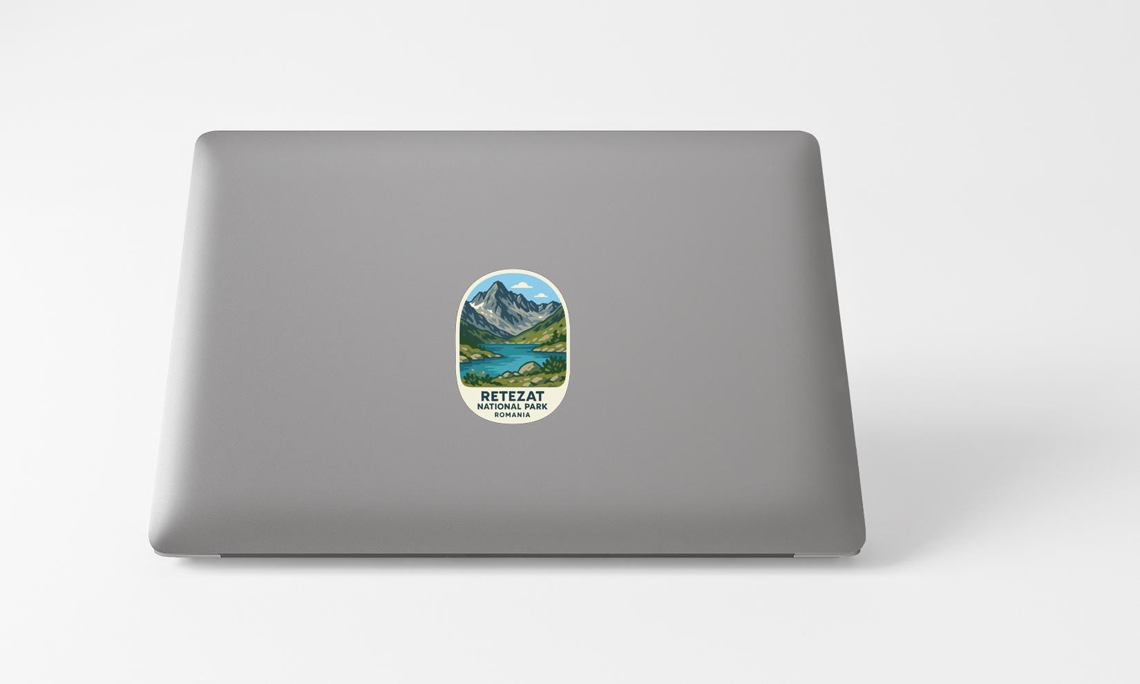 A sticker with a mountain landscape and lake on a laptop.
