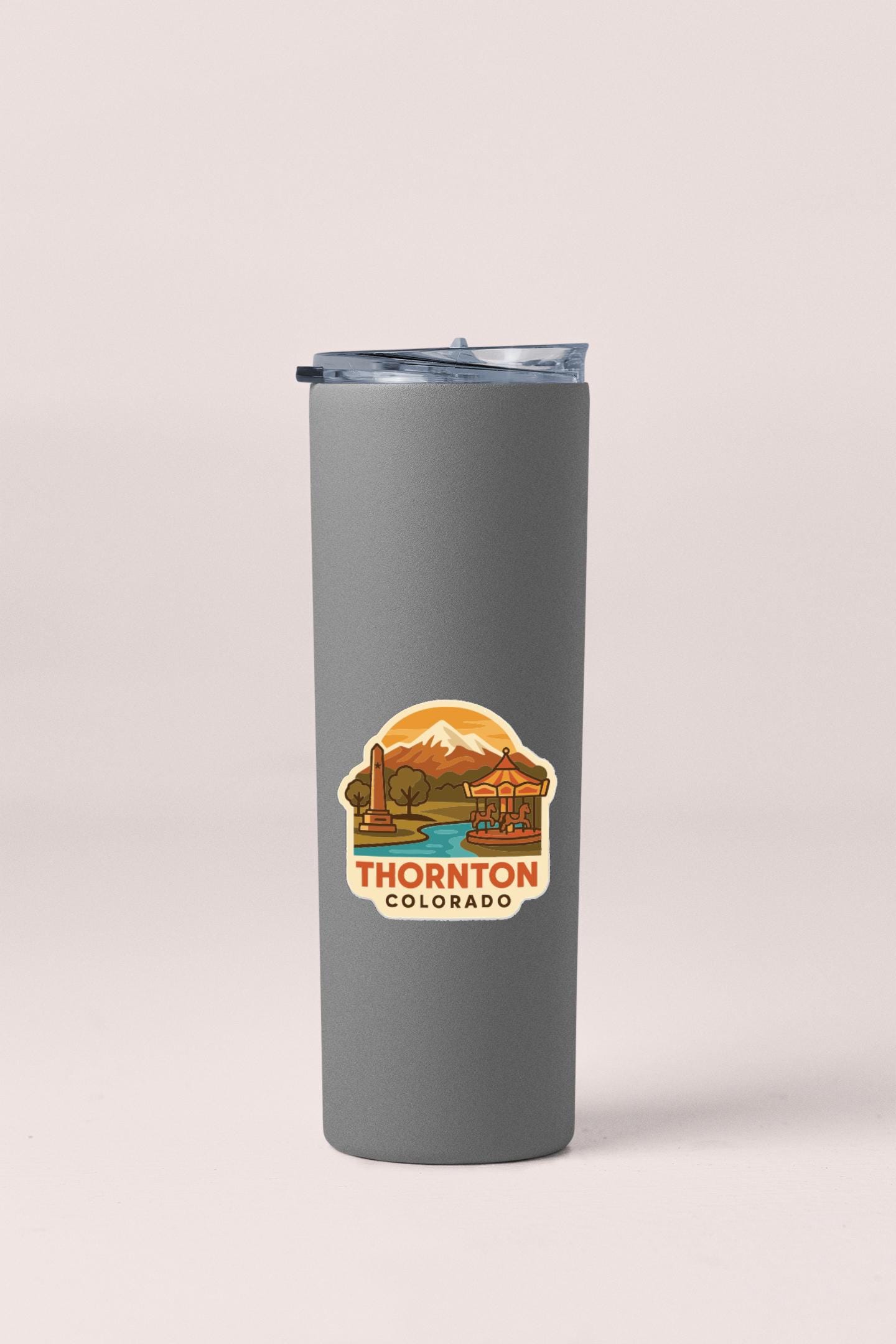 A gray insulated tumbler with a lid and a printed label that says "THORNTON COLORADO".