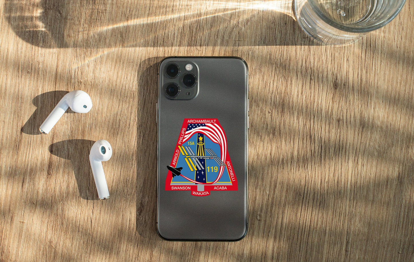 a phone with a sticker on it next to ear buds