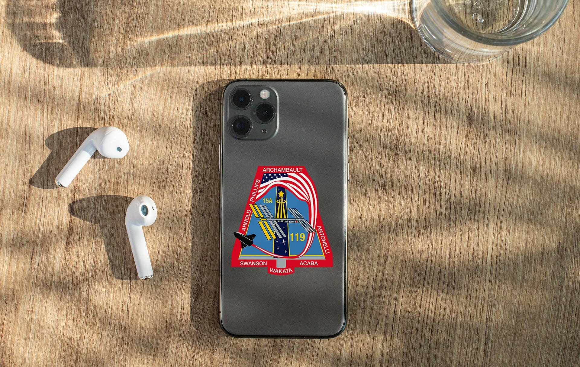 a phone with a sticker on it next to ear buds