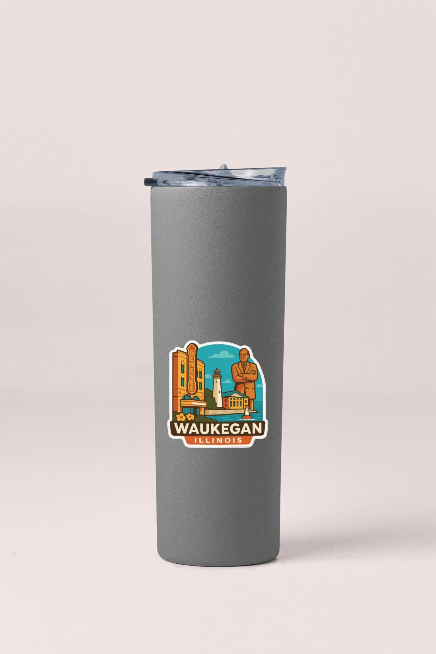 A gray insulated tumbler with a sticker depicting the Waukegan, Illinois area.