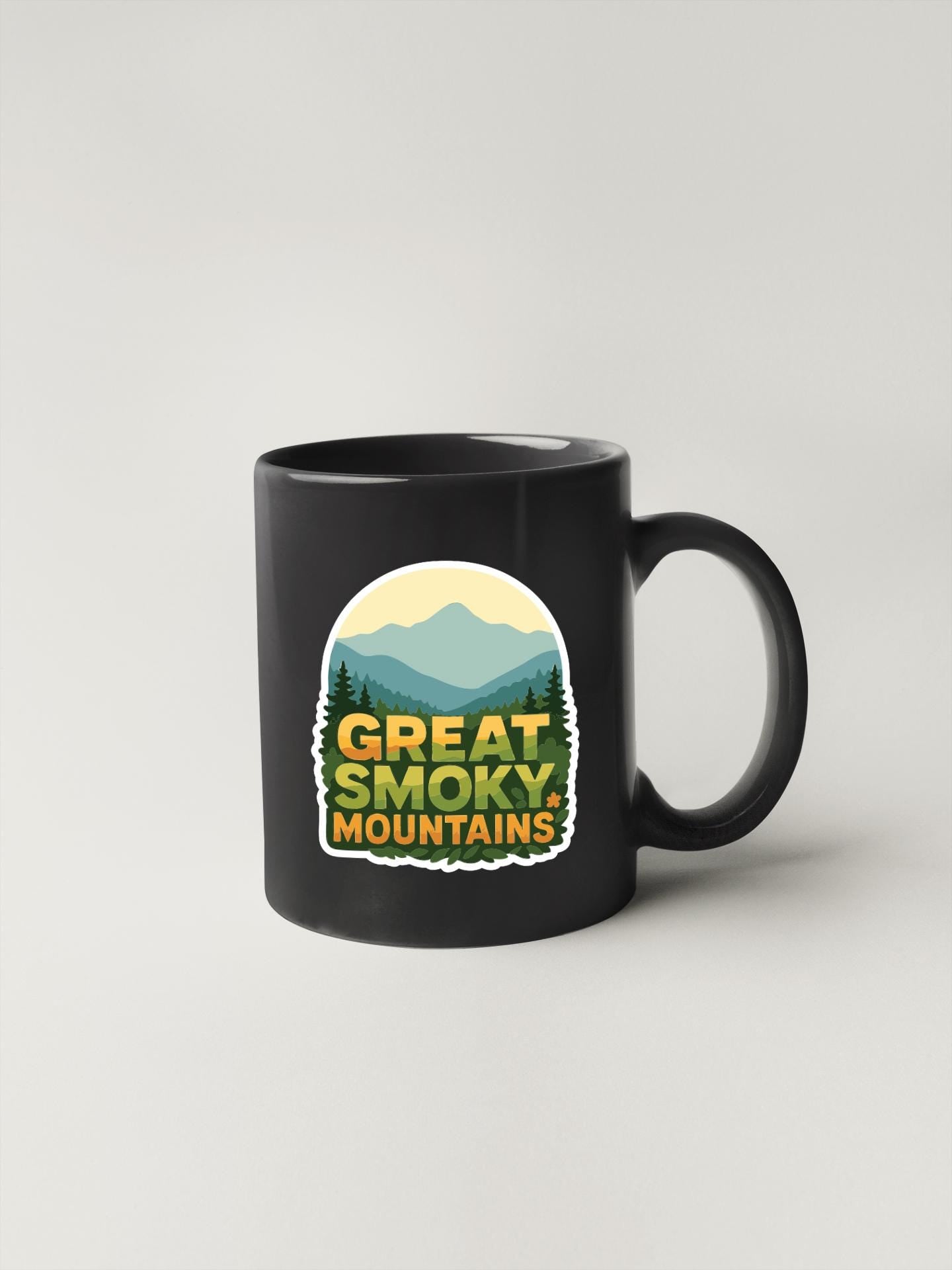A black coffee mug with a graphic design featuring mountains and the text "GREAT SMOKY MOUNTAINS".