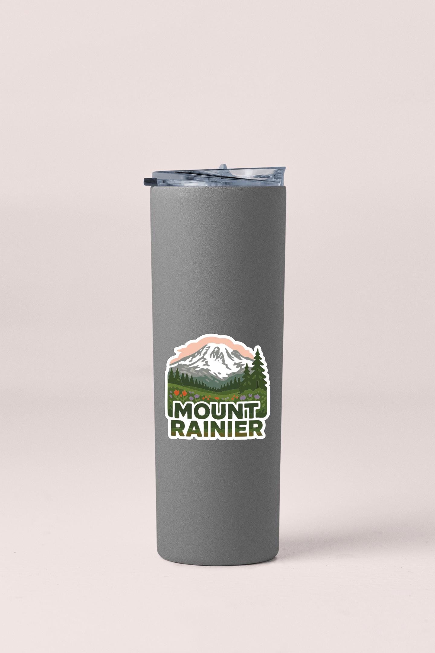 A gray insulated tumbler with a mountain landscape sticker on it.