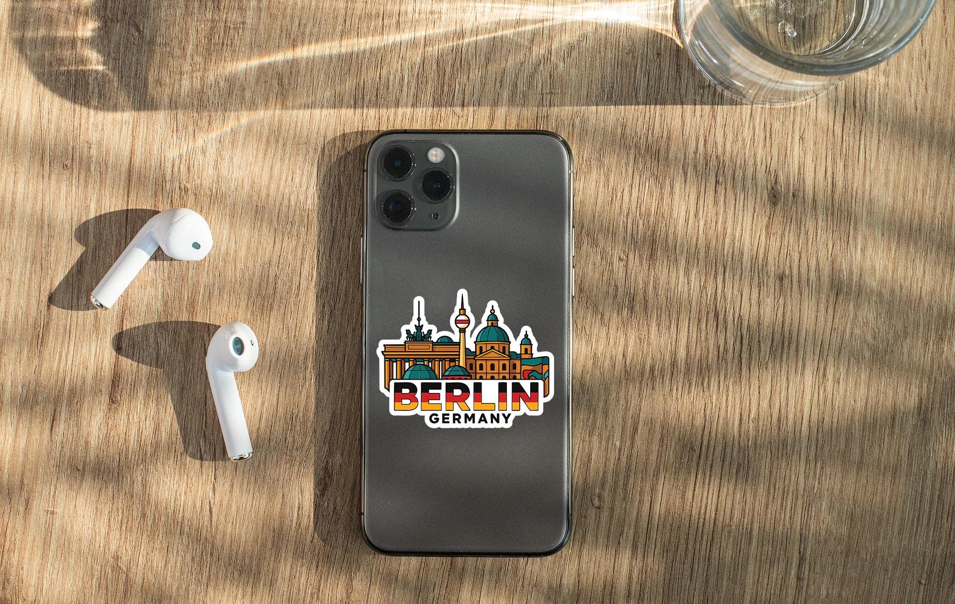 a phone with a sticker on it next to ear buds