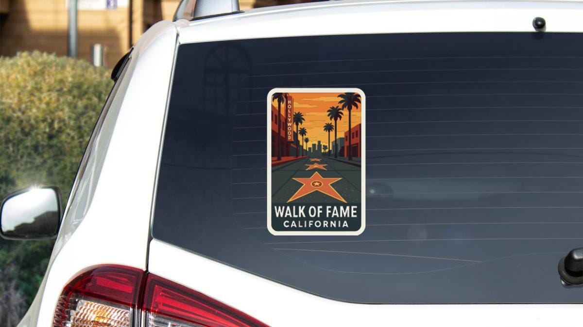 a sticker on the rear window of a white car, depicting a scenic road leading to a star.