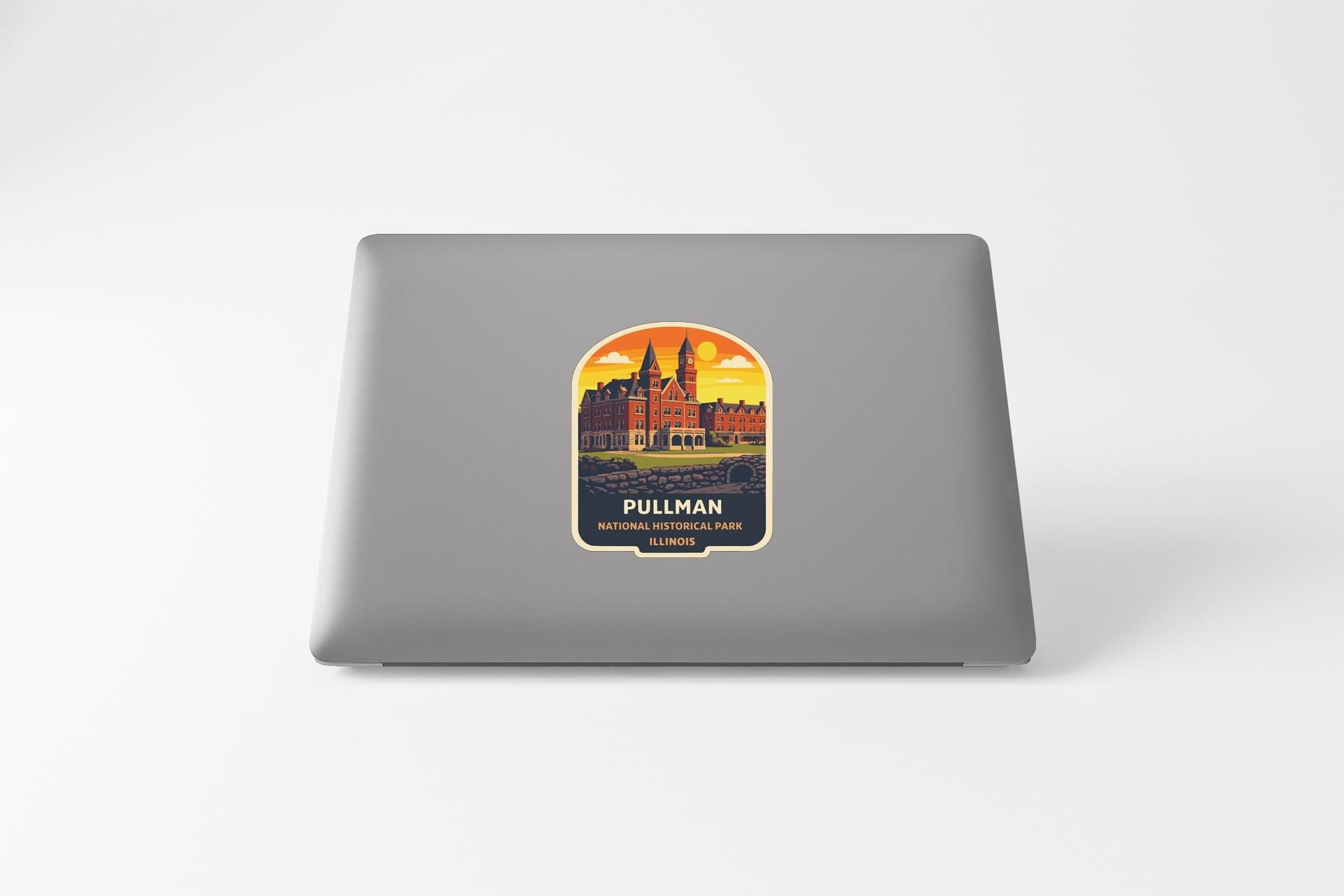 A sticker on the back of a laptop, depicting a cityscape with a castle-like structure in the background.