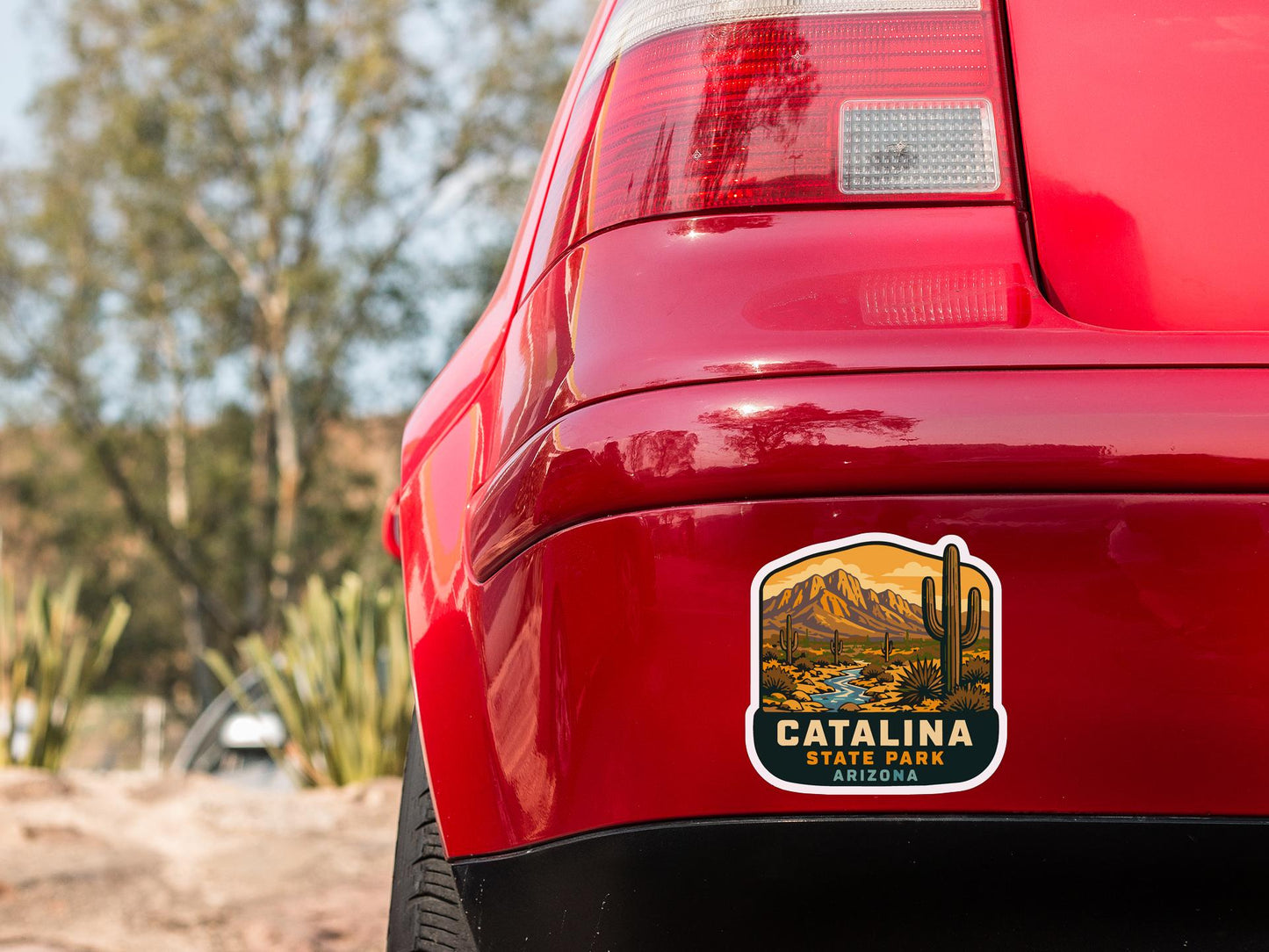 the rear end of a red car with a sticker on the back window that says "Catalina State Park Arizona".