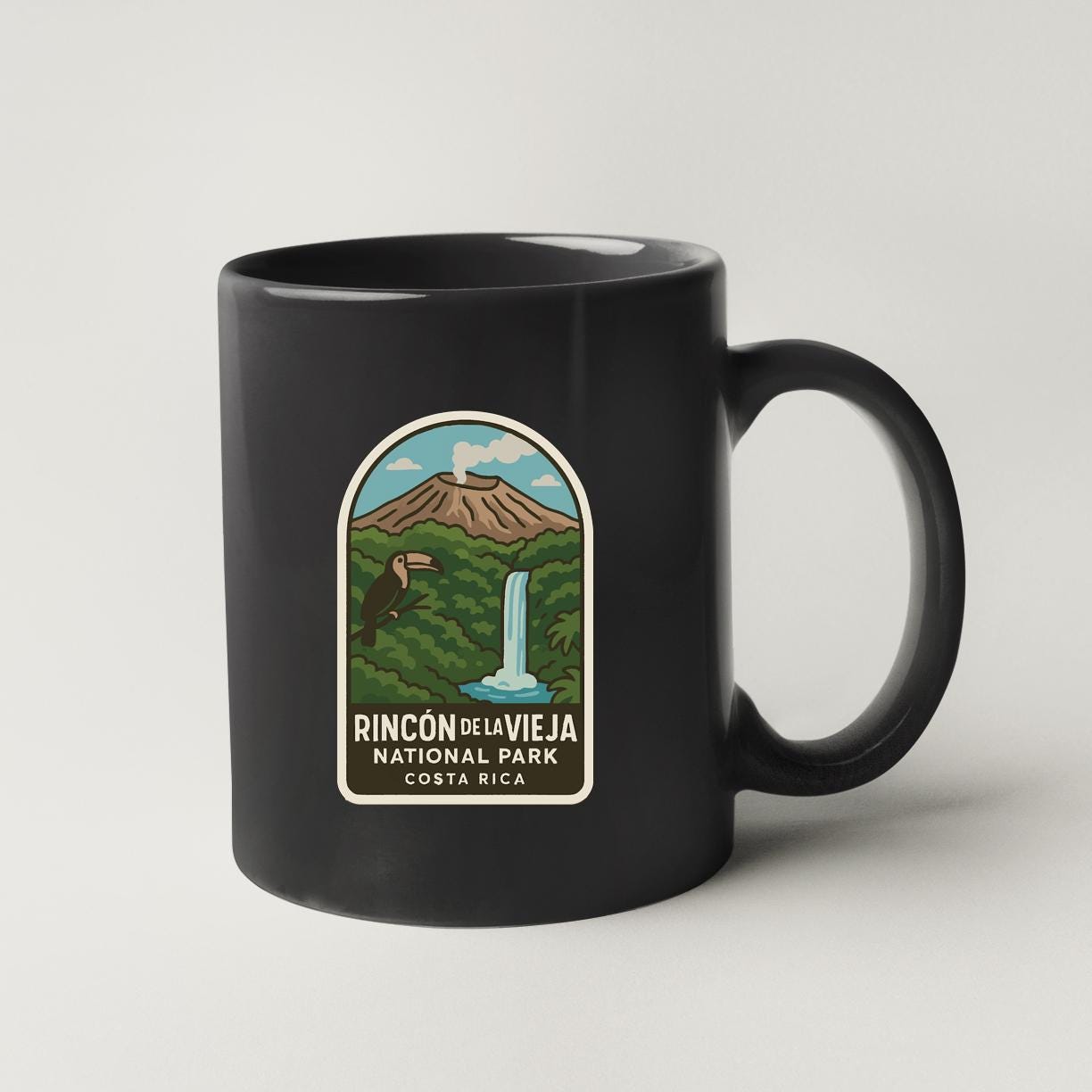 A black coffee mug with a label that says "RINCON DE LA VIEJA NATIONAL PARK, COSTA RICA".