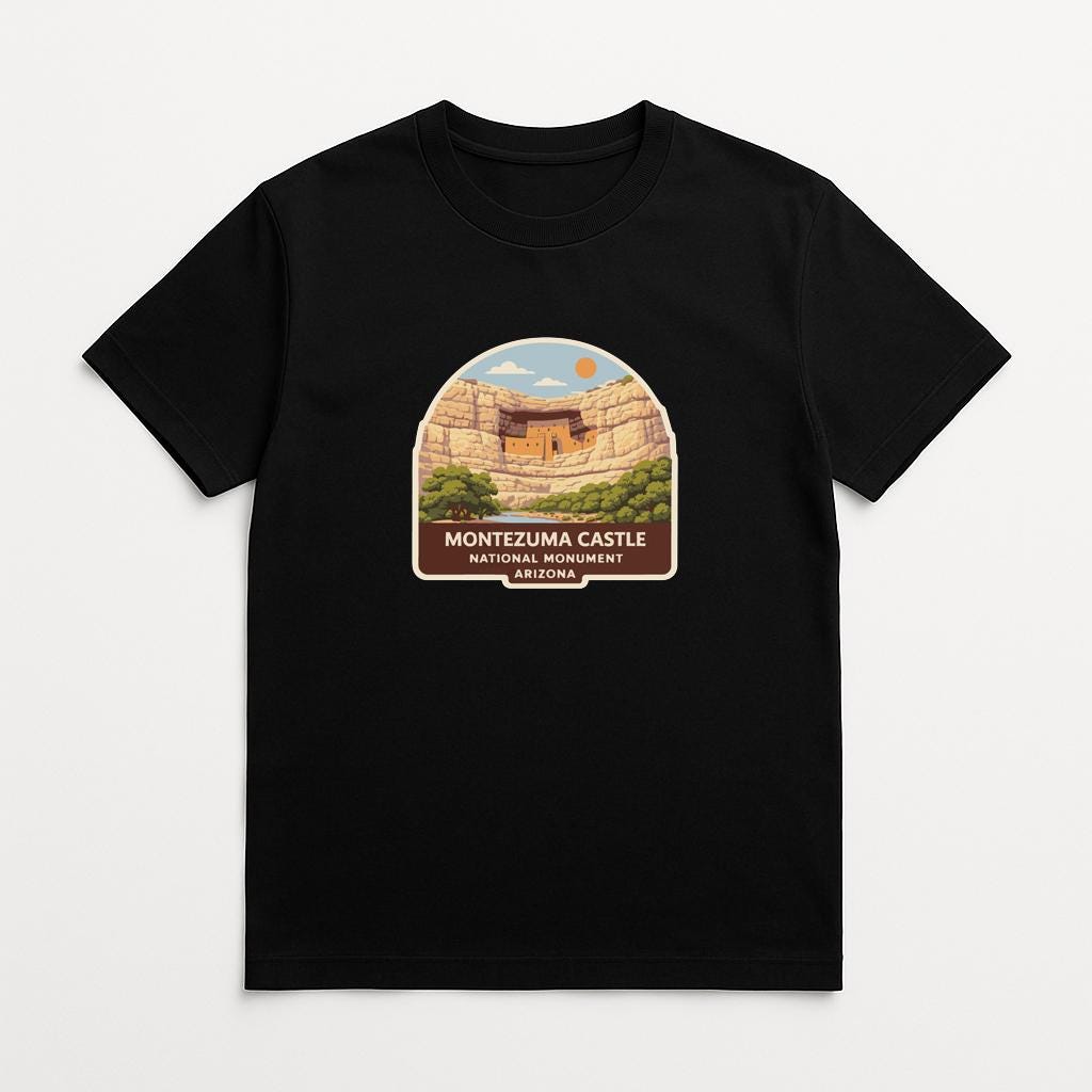 A black t-shirt with a graphic design depicting the Montezuma Castle in Arizona.