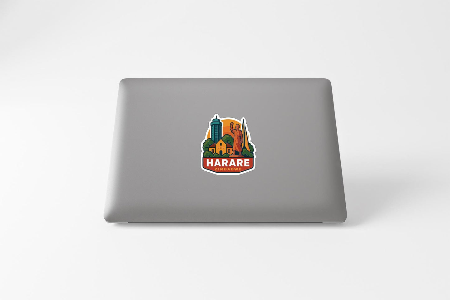 a sticker with a colorful illustration of a cityscape and the text "HARARE" on a laptop.