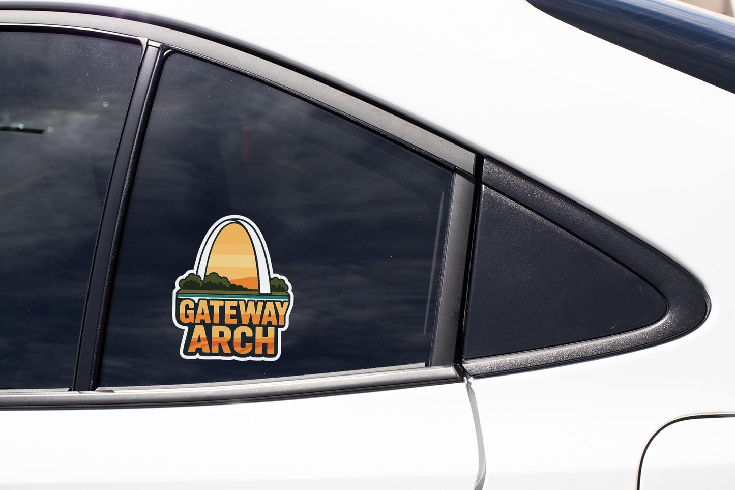 A close-up of a car window with a sticker on it, featuring the text "GATEWAY ARCH".