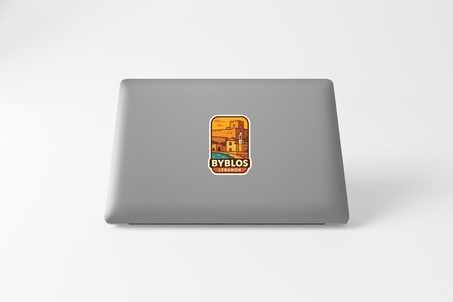 A sticker on the back of a laptop, featuring an illustration of a building and the text "BYBLOS" and "CERVEZA".