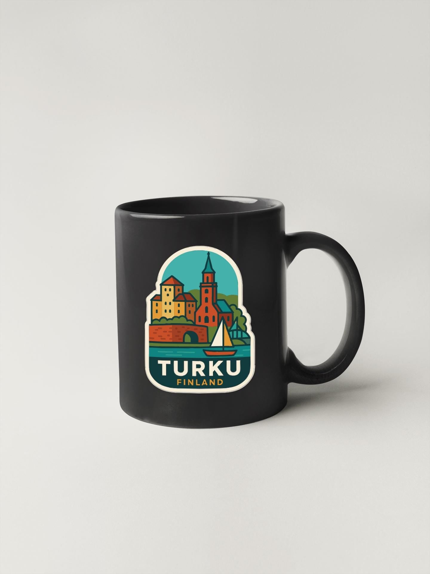 A black coffee mug with a colorful illustration of a cityscape and the text "TURKU FINLAND" printed on it.