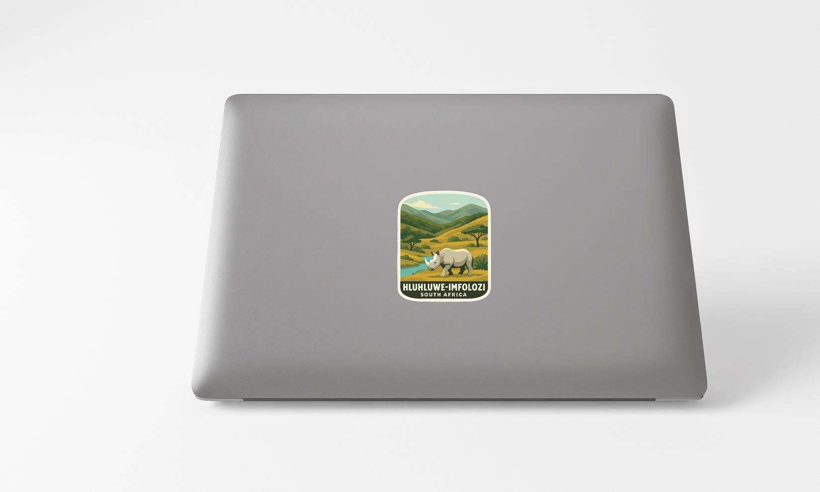 A sticker on the back of a laptop, depicting a rhinoceros in a natural landscape.