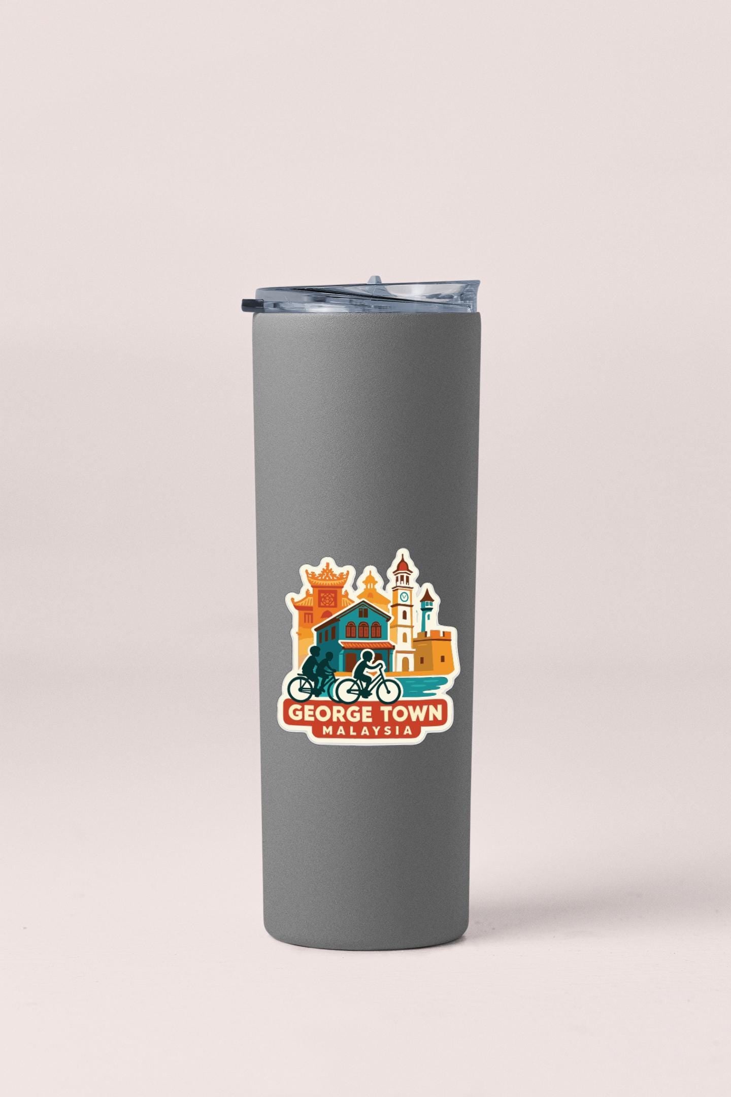 A gray insulated tumbler with a sticker depicting a city skyline and a bicycle.