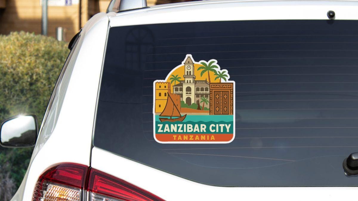 A sticker on the rear window of a car, depicting landmarks and buildings associated with Zanzibar City, Tanzania.