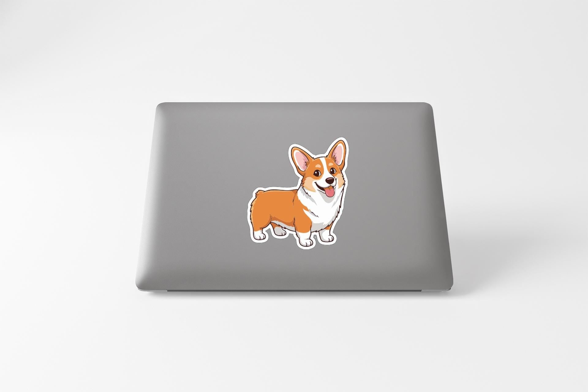 A sticker of a corgi dog is placed on the back of a laptop computer.