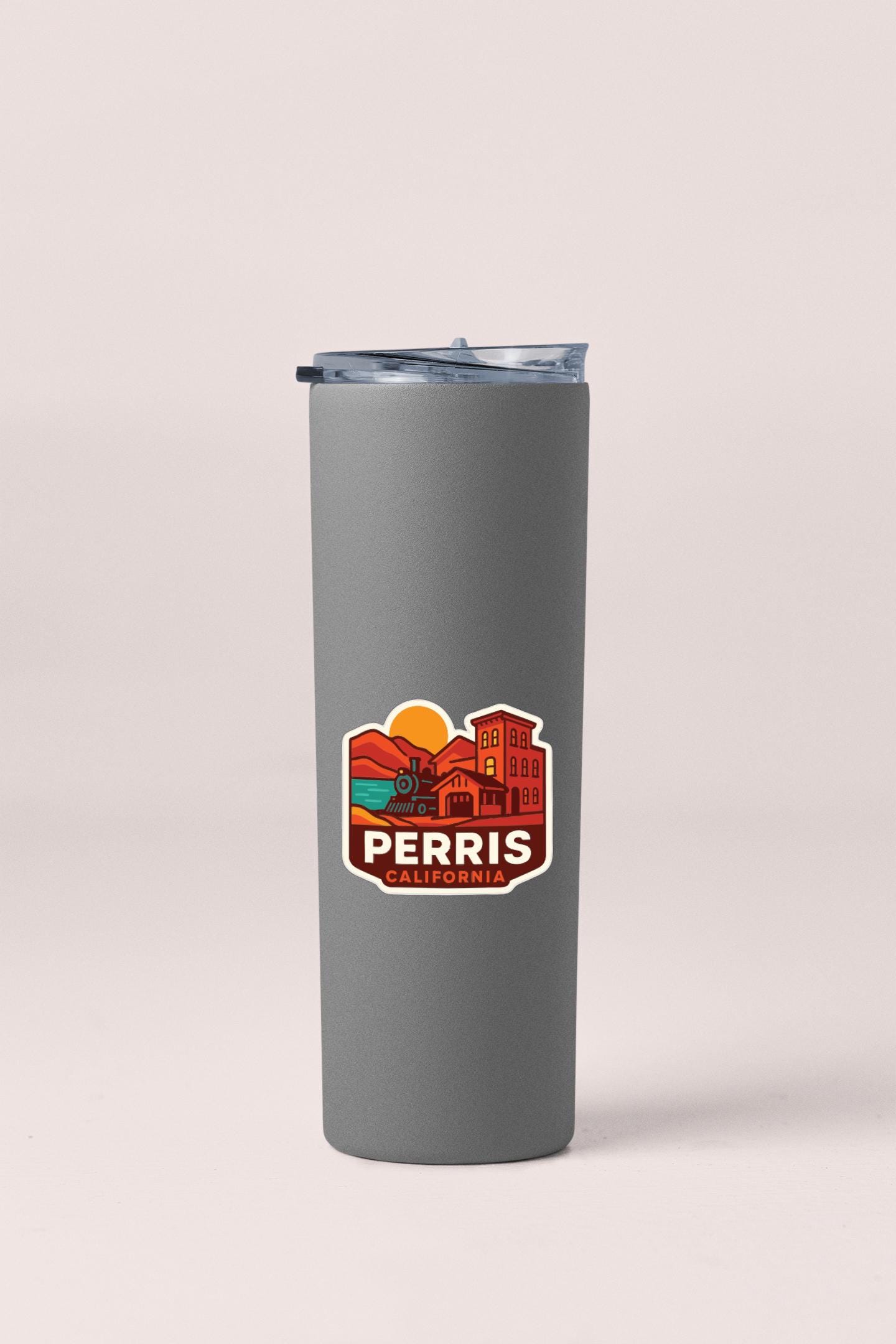 A gray insulated tumbler with a lid and a sticker featuring a colorful illustration of a cityscape.