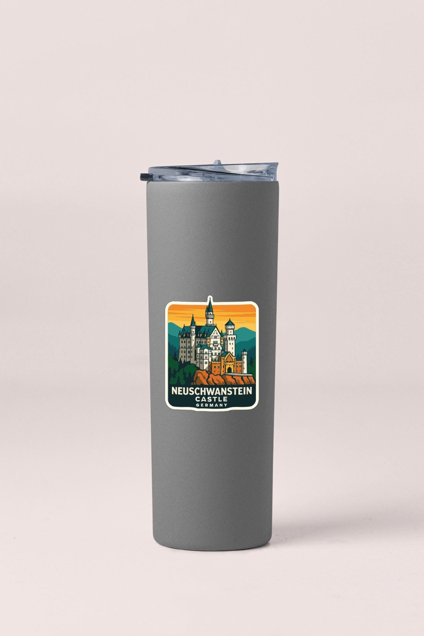 A gray insulated tumbler with a sticker depicting the Neuschwanstein Castle in Germany.