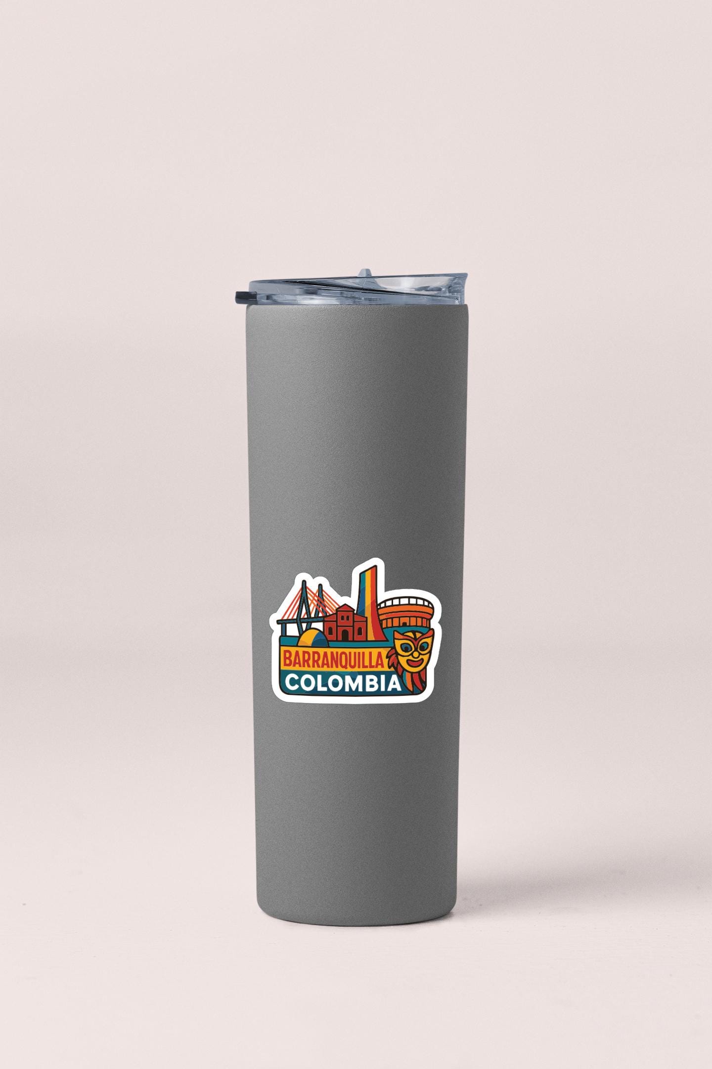 A gray insulated tumbler with a colorful sticker depicting the city of Barranquilla, Colombia.