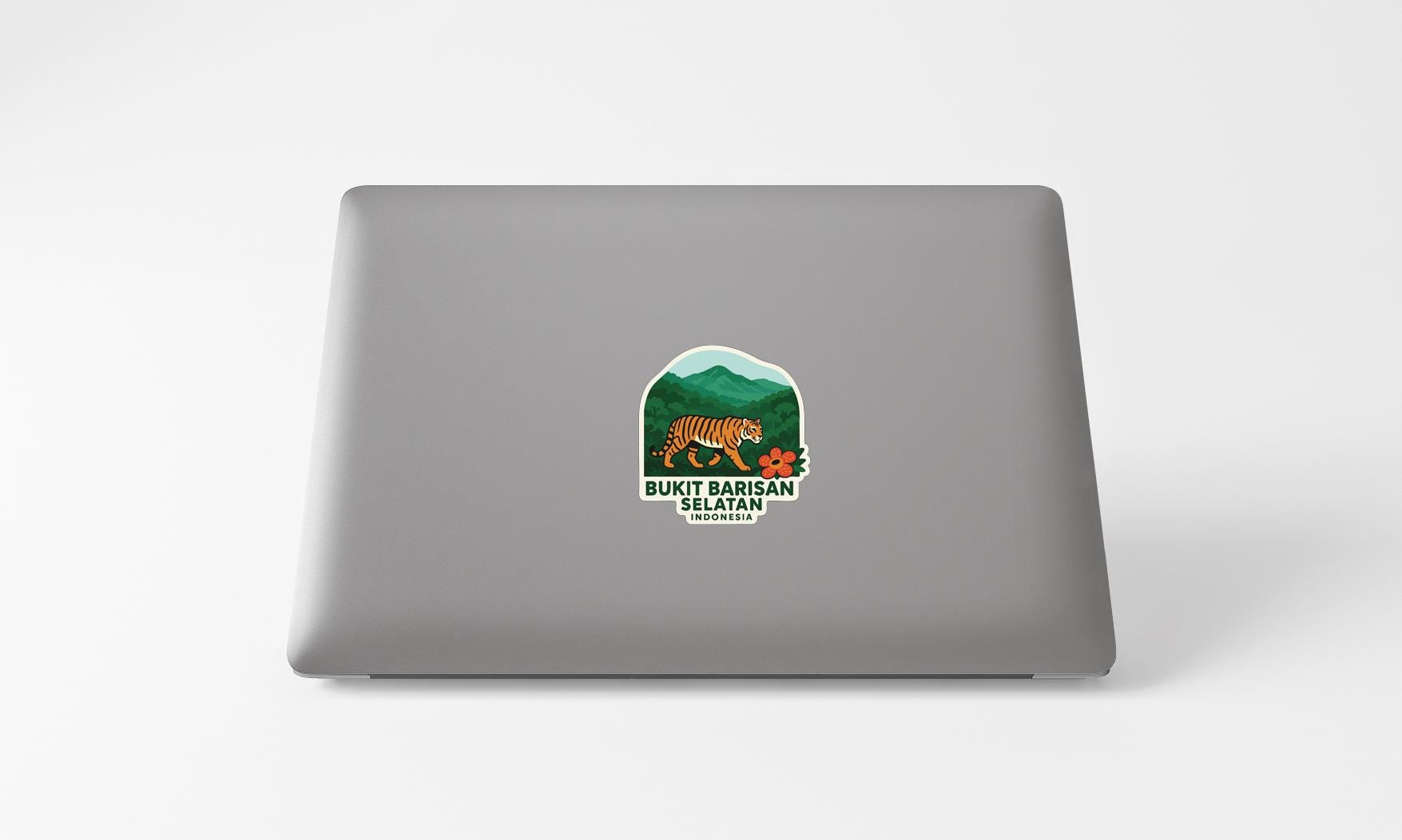 a sticker with a tiger and mountains on a laptop.