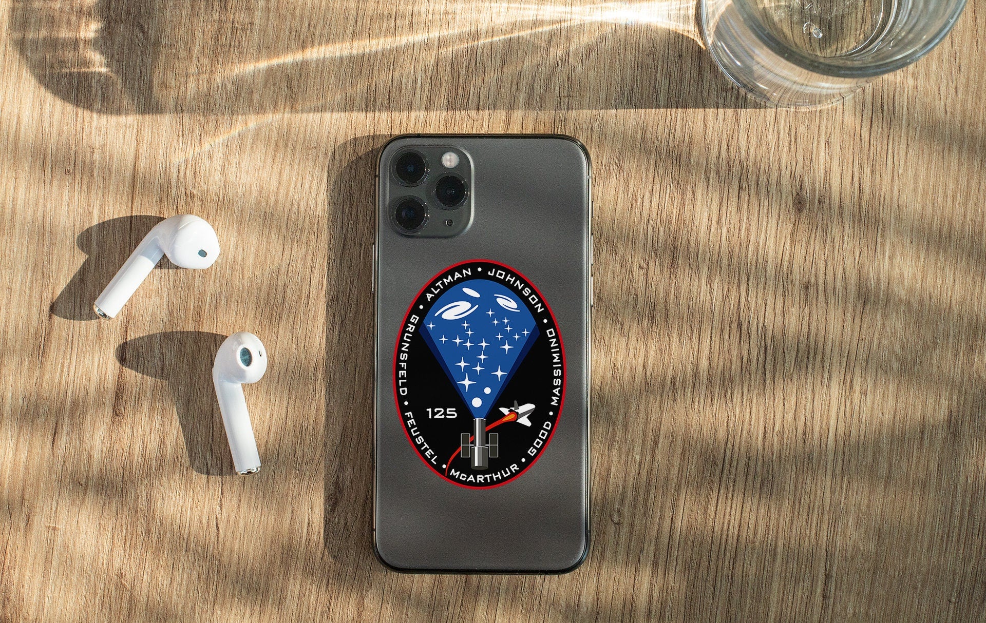 a phone with a sticker on it next to ear buds
