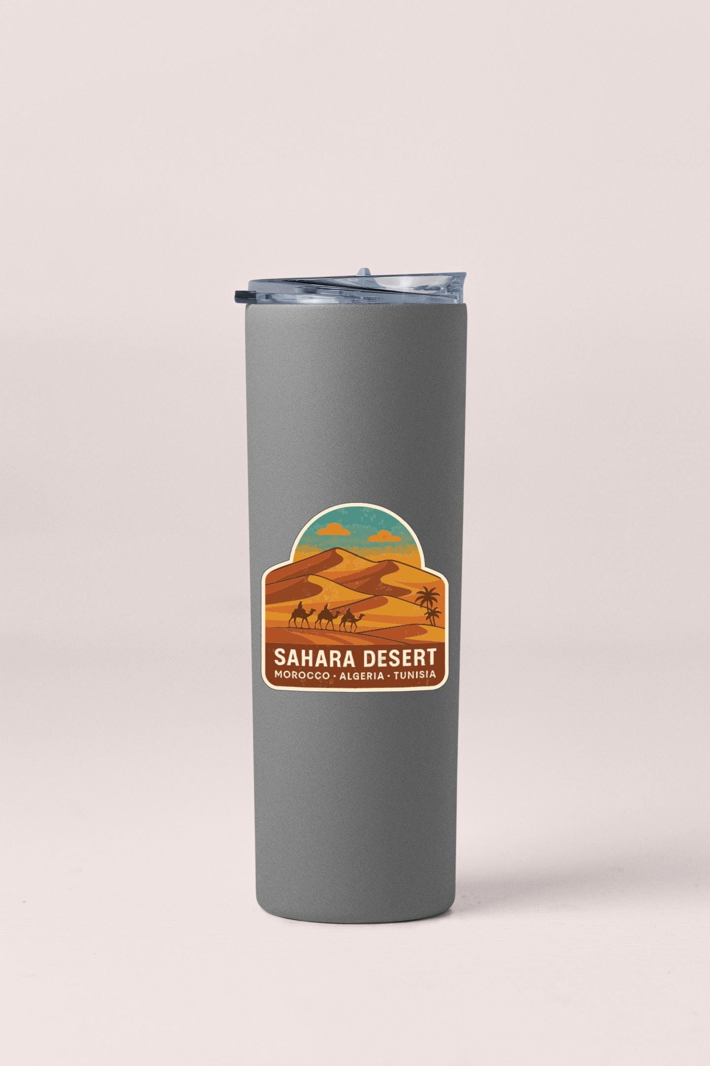 A gray insulated tumbler with a label that says "SAHARA DESERT" and "MOROCCO - ALGERIA - TUNISIA".